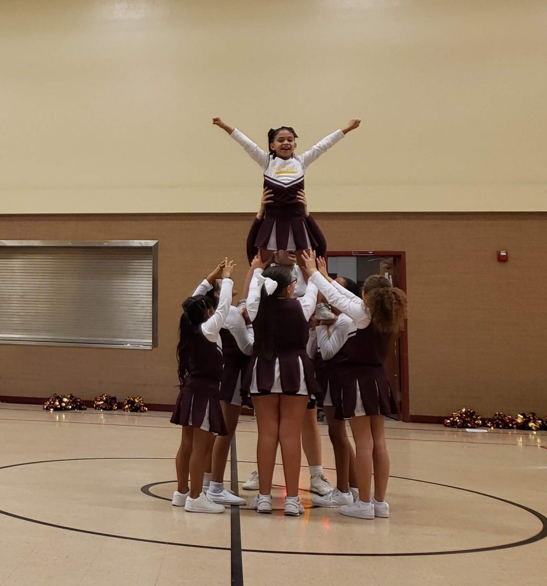 Academy Del Sol Firebirds cheer squad performing at a school game